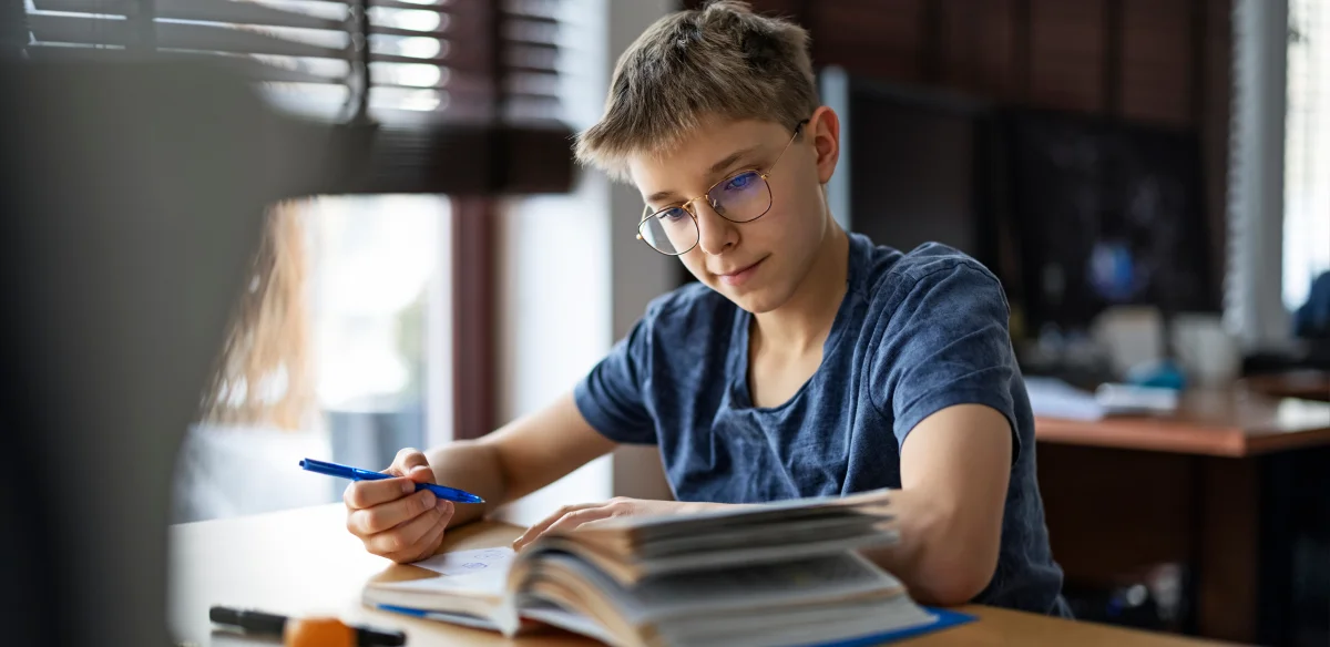 Student taking notes at home